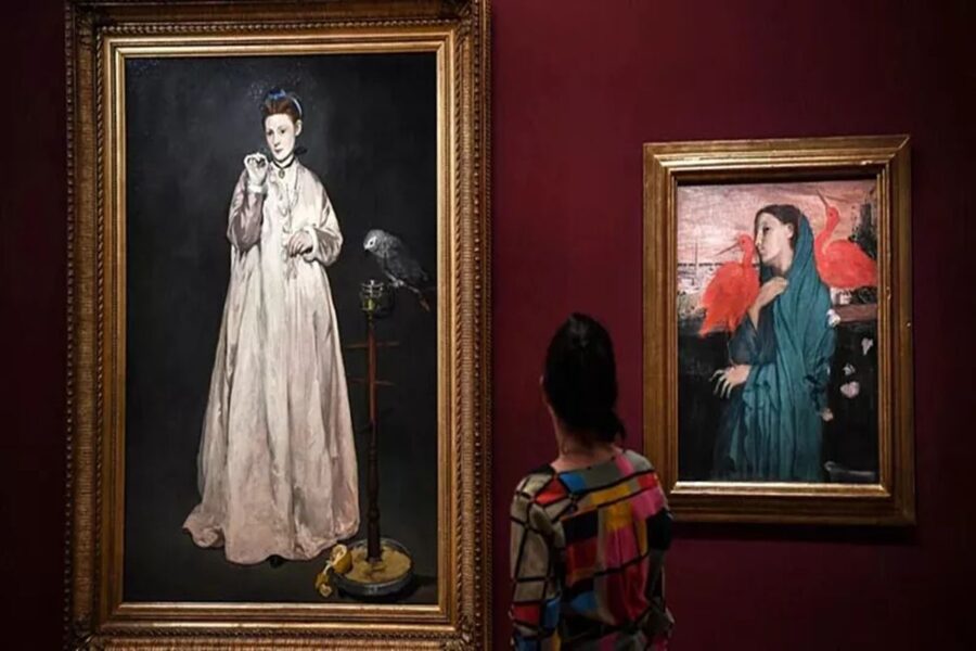 Art gallery features classical paintings and observer on a red wall background.