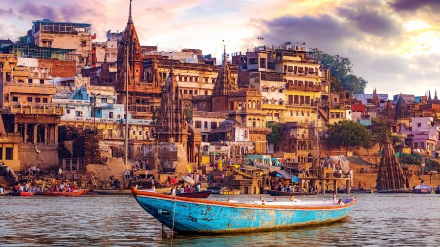 Varanasi ghats at sunset: boats, temples, people, and spirituality along the Ganges River.