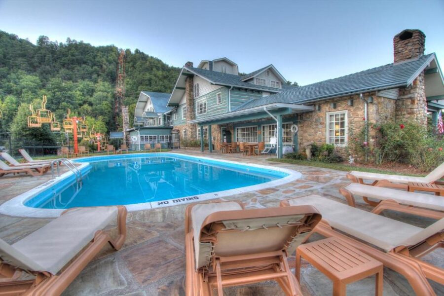 The Gatlinburg Inn features a pool and lounge chairs, inviting relaxation in a scenic outdoor setting.