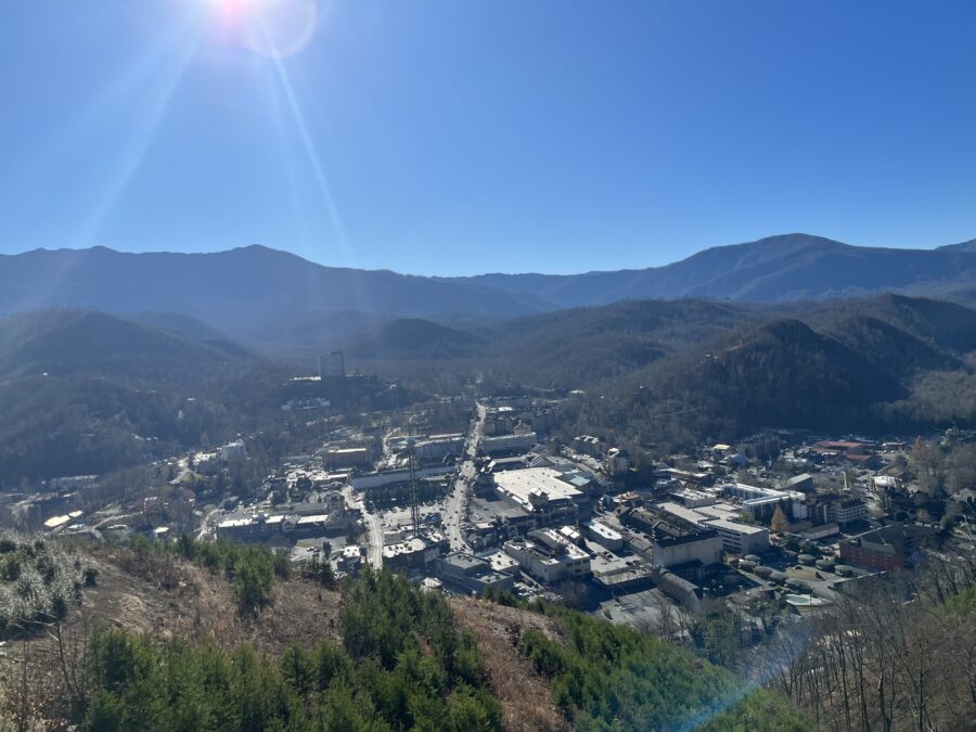 Bright sun illuminates Gatlinburg SkyLift Park, showcasing a scenic city nestled in the mountains.
