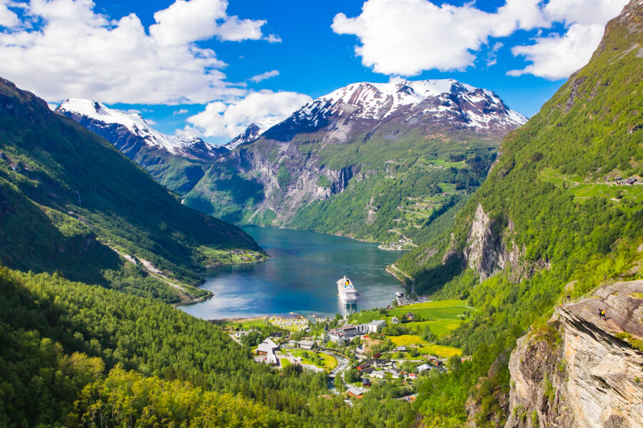 Panoramic view of Geirangerfjord, showcasing its stunning cliffs, lush greenery, and serene waters in Norway