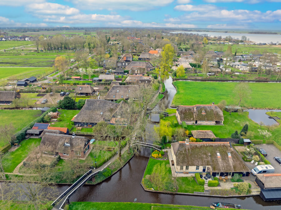 Aerial view of the historic village of Giethoorn in the Netherlands, showcasing its canals and thatched-roof houses.
