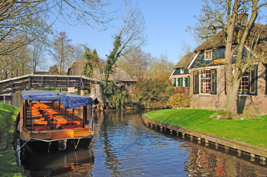 Scenic view of Giethoorn's canals and thatched-roof houses, showcasing the charm of the historic old town.
