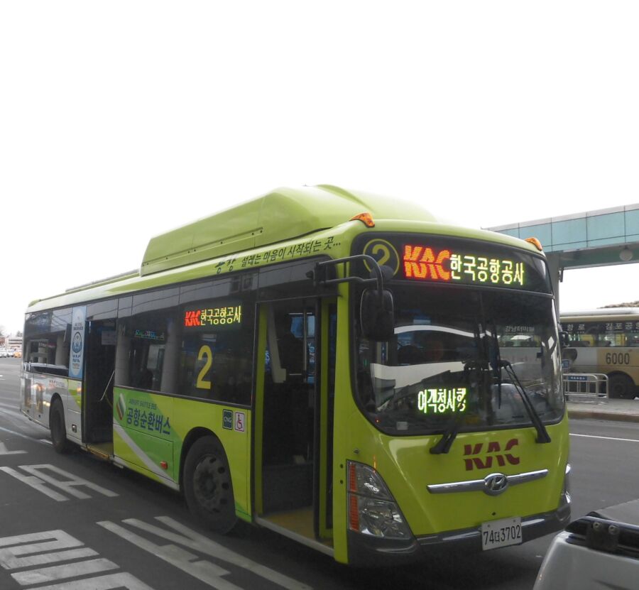 The Gimpo International Airport Shuttle Bus is stationed at a bus stop, prepared for incoming passengers.