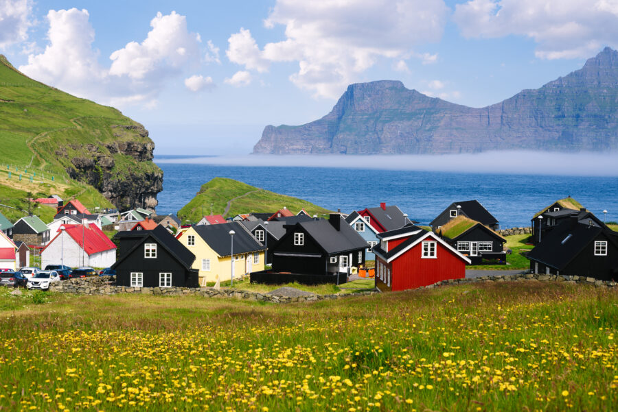 Gjogv village on Eysturoy island, Faroe Islands, featuring colorful houses and dramatic coastal cliffs.
