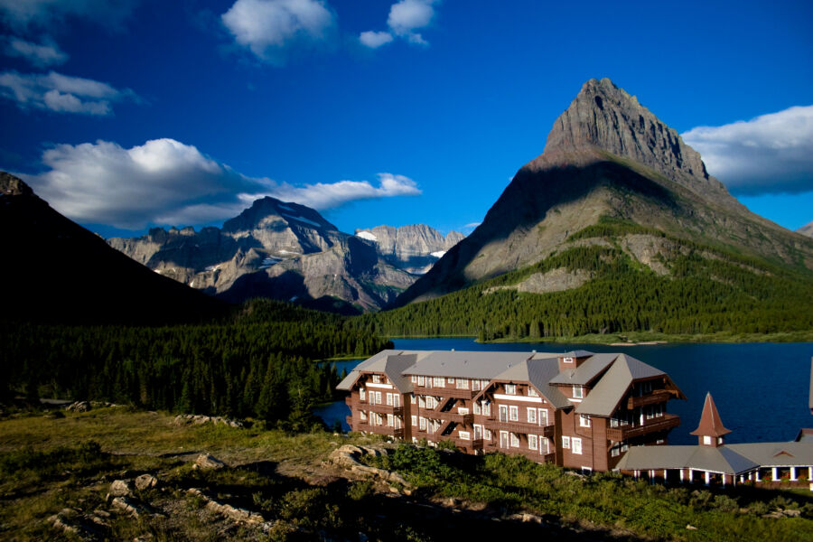 Glacier National Park lodge with mountain peaks, lake, and coniferous forests in stunning scenery.