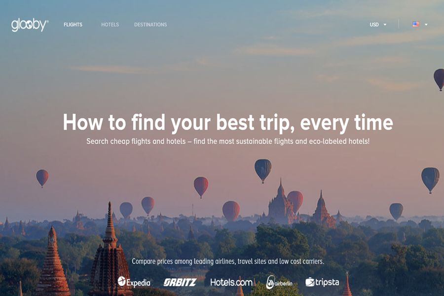 Travel website homepage with hot air balloons and eco-friendly flight and hotel search.