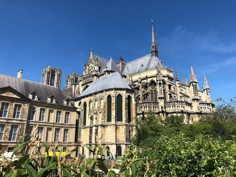 Notre-Dame de Reims Cathedral: Gothic spire, flying buttresses, and ornate apse in France.