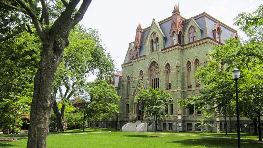 Gothic revival architecture at University of Philadelphia with lush landscape on a sunny day.