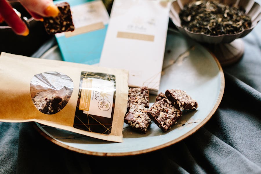 Cozy setup with chocolate bars, nuts, tea leaves, and colorful packaging.
