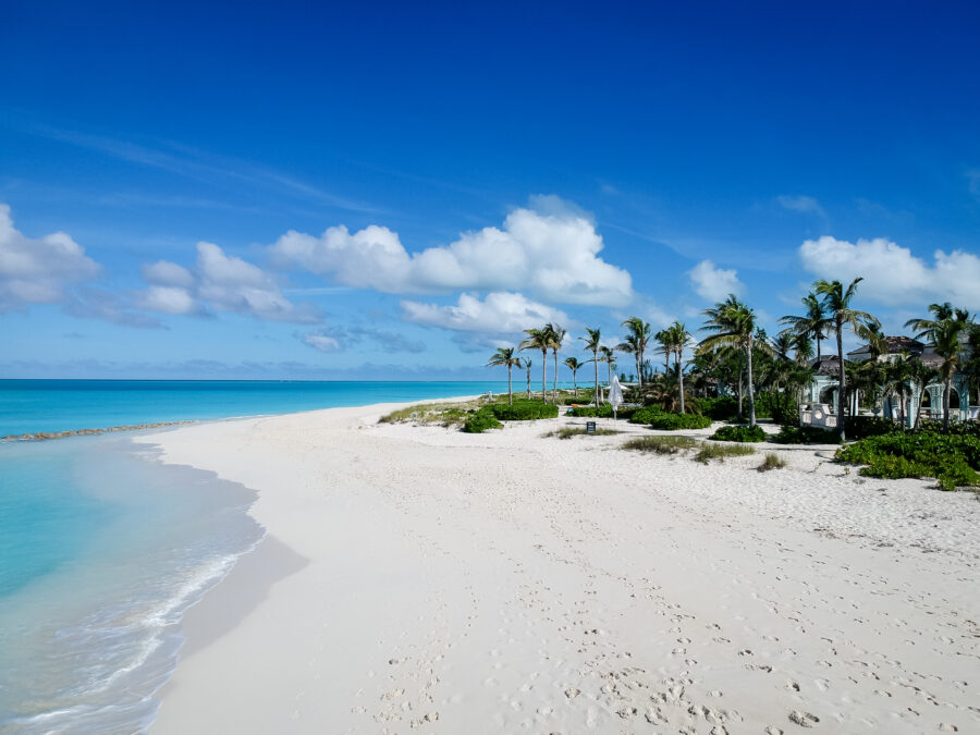 Panoramic view of a pier in Grace Bay, Providenciales, Turks and Caicos Islands, with crystal-clear waters surrounding it.