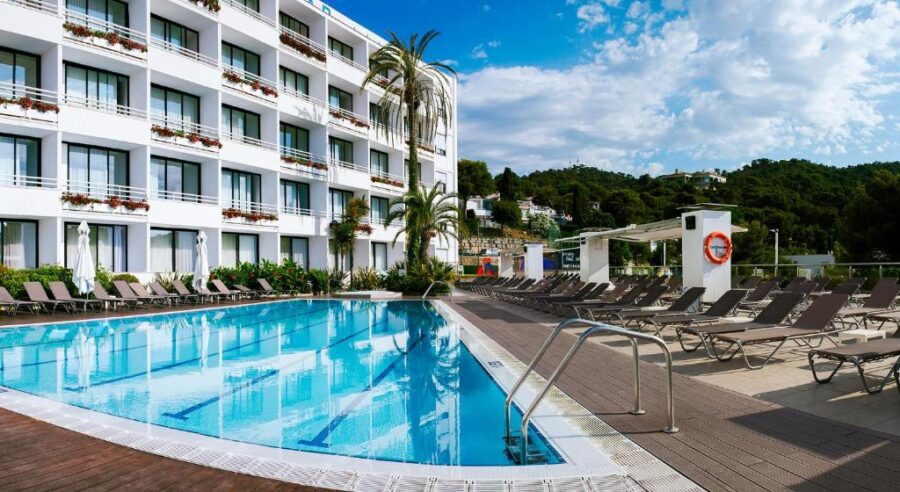 Hotel pool at Gran Hotel Reymar 4 Sup in Spain, featuring lounge chairs and sun umbrellas for relaxation.