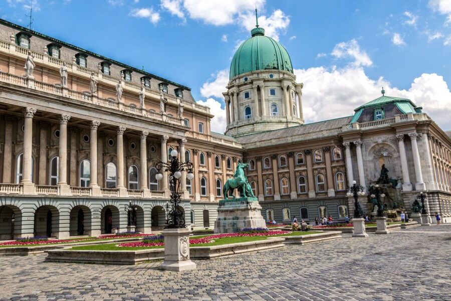 Majestic Hungarian National Gallery in Buda Castle, Budapest, with courtyard and vibrant visitors.