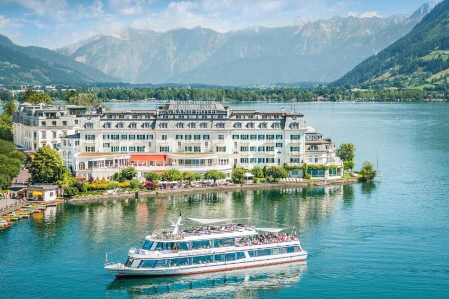 Boat glides across the lake near the Grand Hotel Zell am See, with picturesque views of the surrounding landscape.
