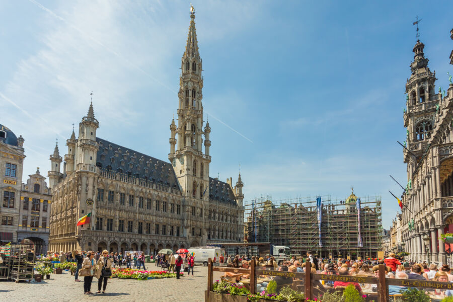 Grand Place in Brussels, Belgium, showcasing ornate architecture and vibrant flowers in a bustling public square
