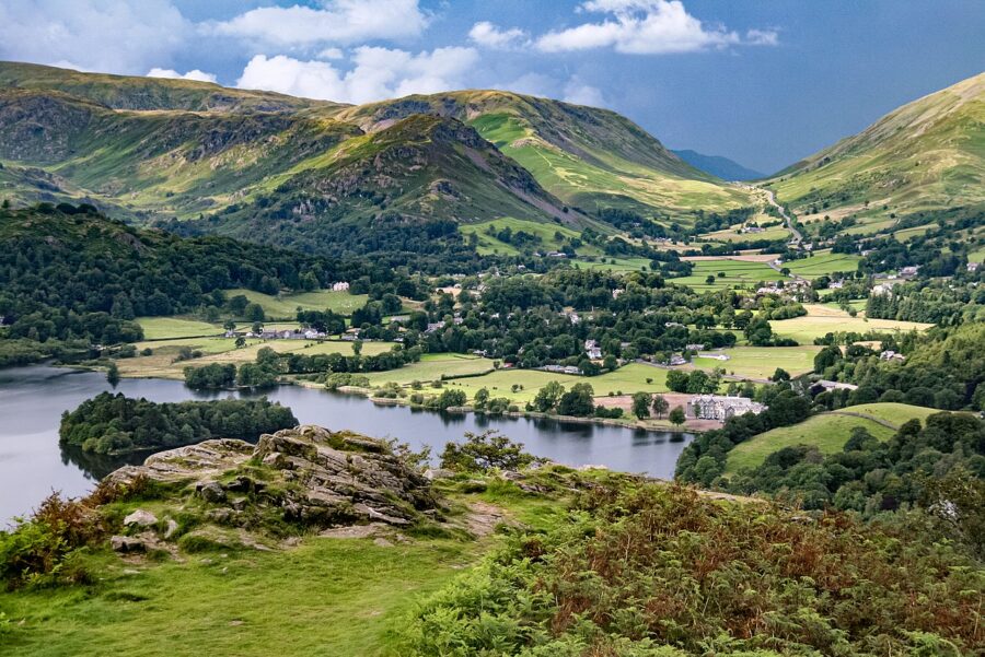 Scenic panorama of Grasmere in the Lake District, showcasing lush hills and tranquil waters in England.