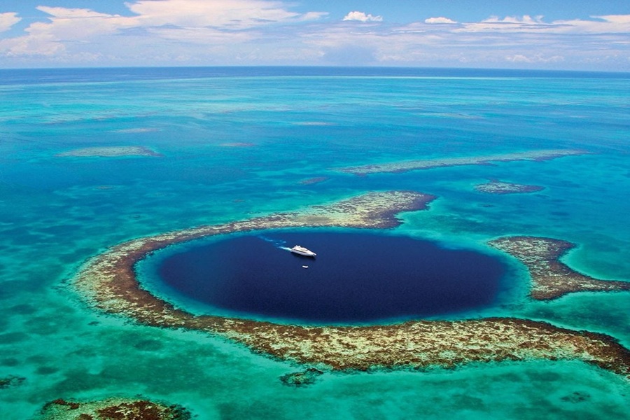 Aerial view of Belizes Great Blue Hole, vibrant marine sinkhole, and coral reef.