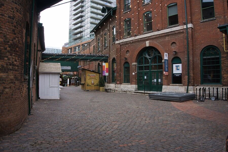 Scenic view of a brick road with a clock tower in the background, located in the Distillery District, Toronto.
