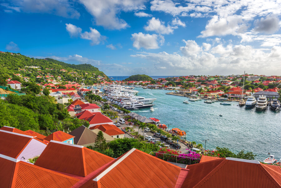 Skyline of Gustavia, St. Barths, featuring colorful buildings and yachts at the harbor under a clear blue sky