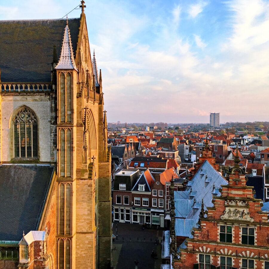 Scenic view of Haarlem, Netherlands, showcasing historic architecture and vibrant city life against a clear blue sky.