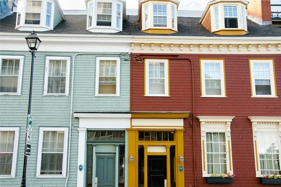 Street corner showcasing a row of colorful houses, including the Halifax Backpackers Hostel.