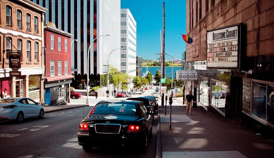 Vehicle travels along a city street in Halifax, Canada, with a building standing prominently in the background.