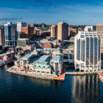 Aerial view of Downtown Halifax, showcasing modern waterfront buildings against a clear sky