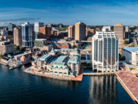 Aerial view of Downtown Halifax, showcasing modern waterfront buildings against a clear sky