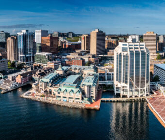 Aerial view of Downtown Halifax, showcasing modern waterfront buildings against a clear sky