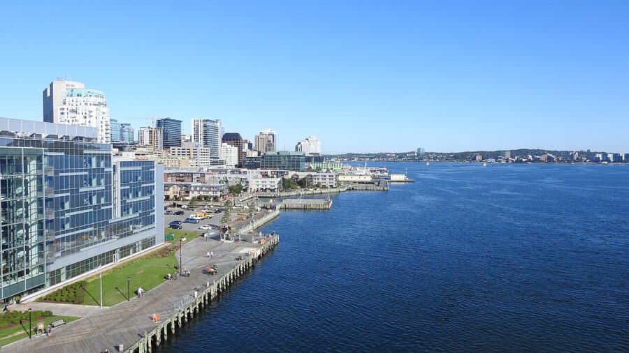 The Halifax Waterfront Boardwalk stretches along a vast body of water, with boats gently bobbing in the waves.