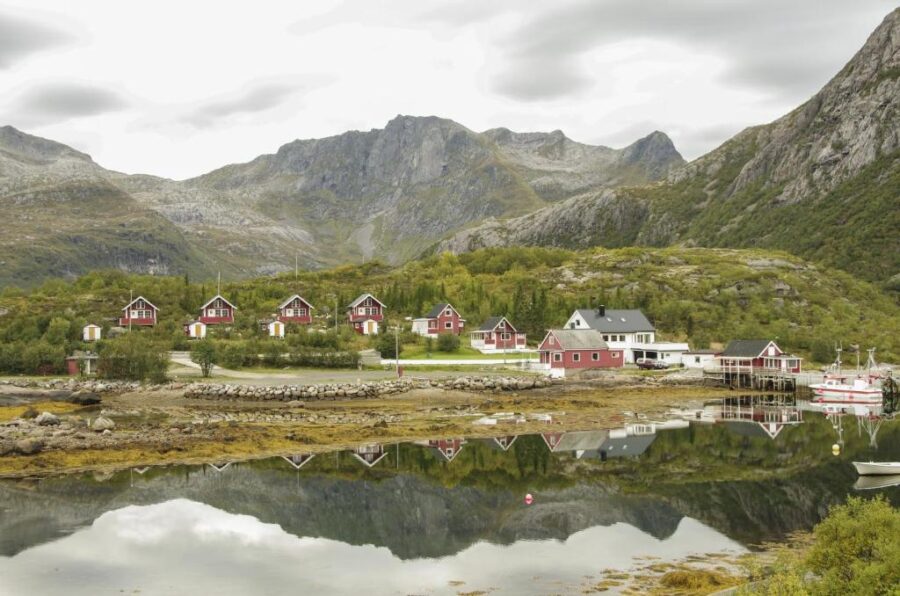 Hammerstad Camping, a picturesque mountain village featuring a boat gently floating in the nearby water.