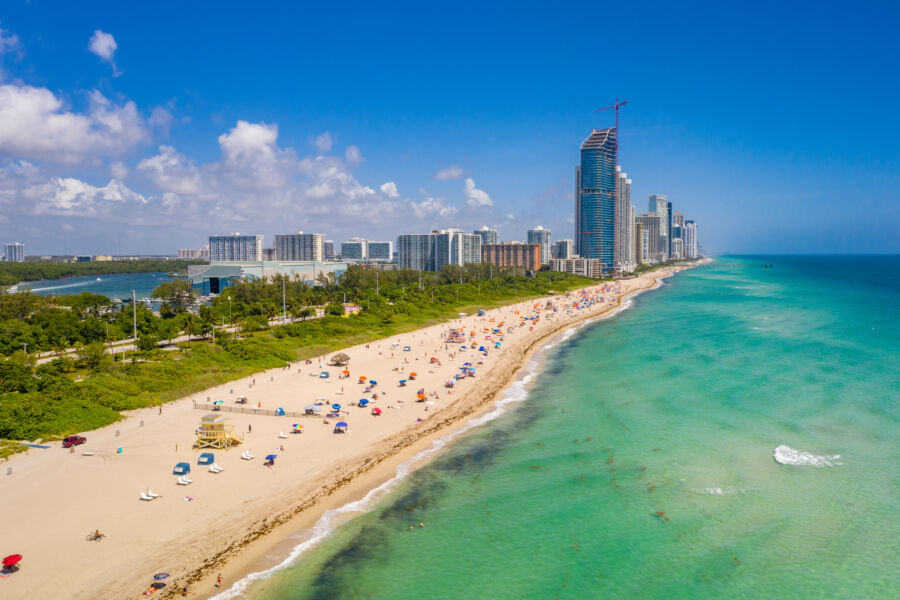 Aerial view of Haulover Park beach in Miami, showcasing sandy shores, turquoise waters, and lush green park areas.