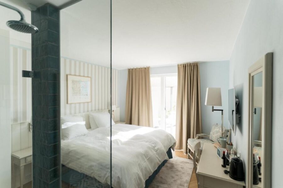 Bedroom at Havgrim Seaside Hotel, featuring a bed, shower, and mirror, set in the Faroe Islands, 1948.