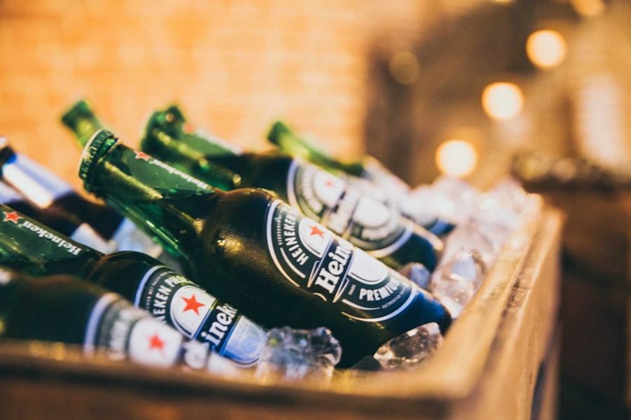 Heineken beer bottles on ice, rustic setting, warm ambiance, perfect for social gatherings.