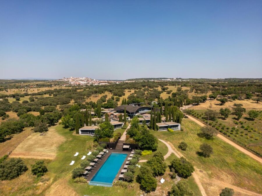 Aerial view of Herdade da Cortesia hotel in Portugal, showcasing the hotel and its inviting swimming pool.