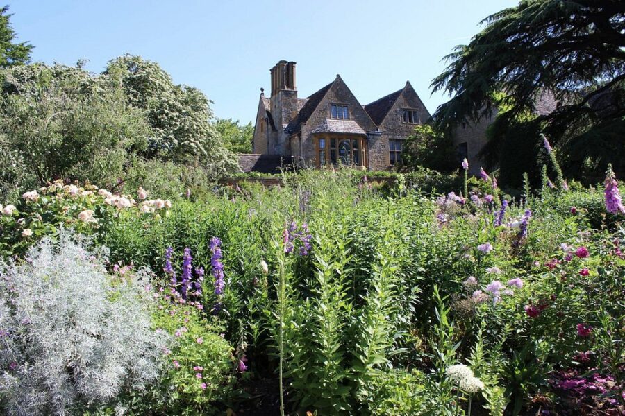 Hidcote Manor Garden, England, featuring a large house and an expansive garden in front.