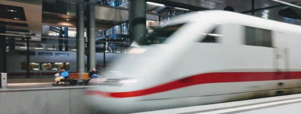 High-speed train in modern station with dynamic architecture and natural lighting.
