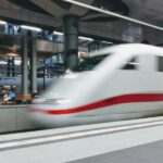 High-speed train in modern station with dynamic architecture and natural lighting.