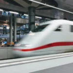 High-speed train in modern station with dynamic architecture and natural lighting.