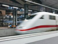 High-speed train in modern station with dynamic architecture and natural lighting.