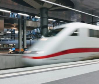 High-speed train in modern station with dynamic architecture and natural lighting.