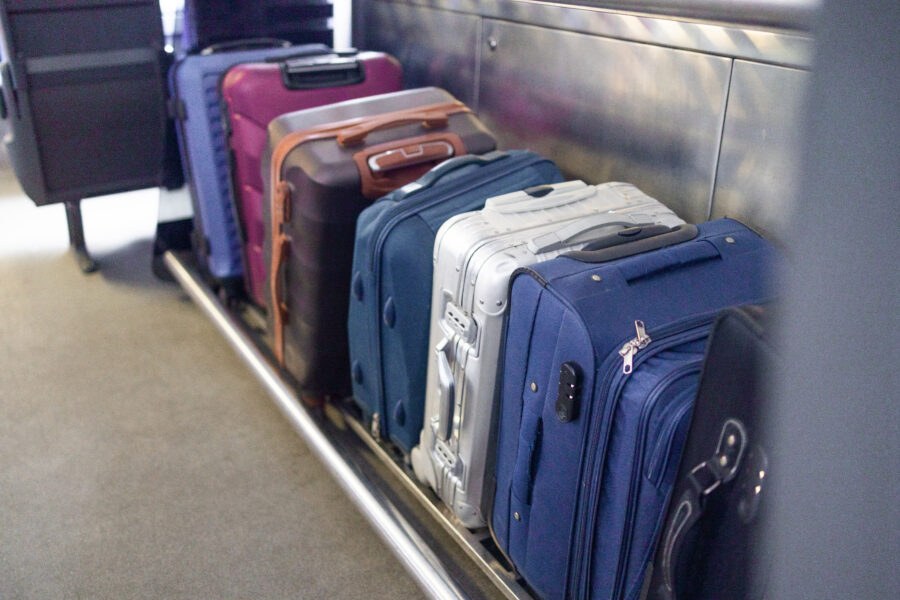 Black suitcase on a shelf in a high-speed train, symbolizing travel and cargo transport for holiday journeys.
