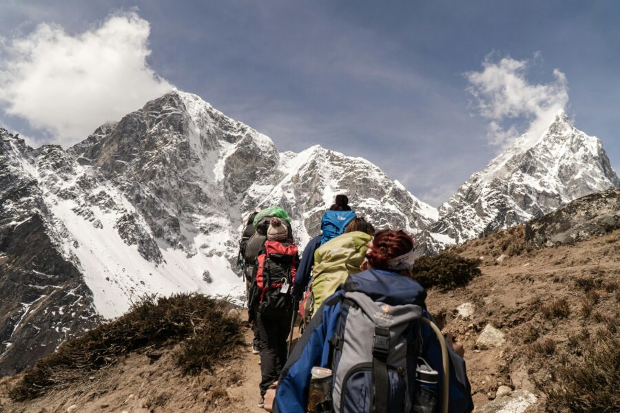 Trekking in the Himalayas: Colorful hikers on a scenic mountain trail.