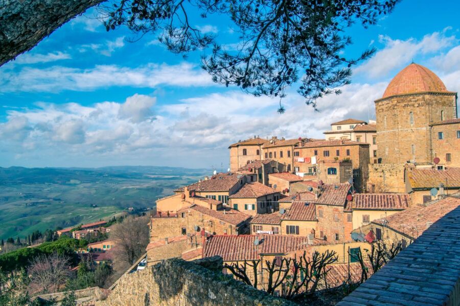 Historic Volterra hilltop town with terracotta roofs and scenic landscape.
