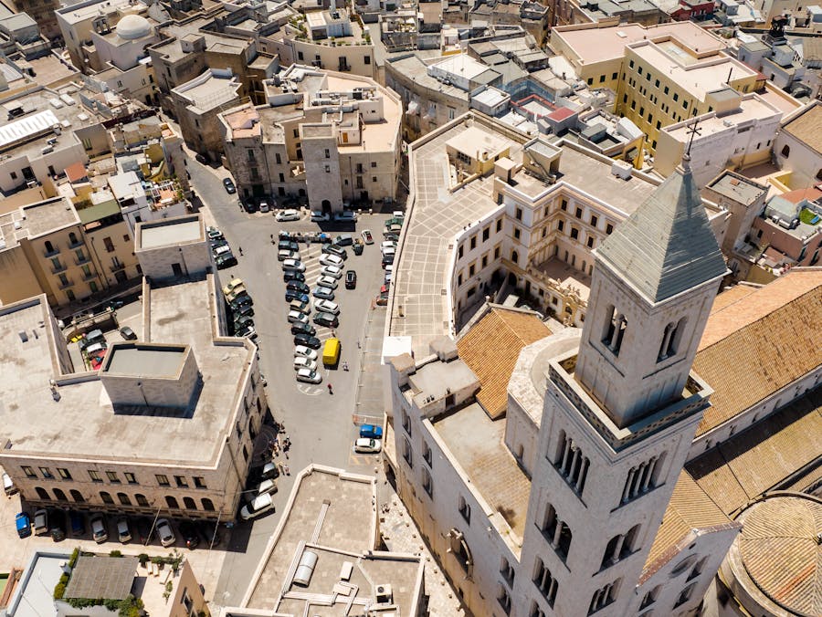 Aerial view of Bari historic bell tower and sunlit Mediterranean rooftops.