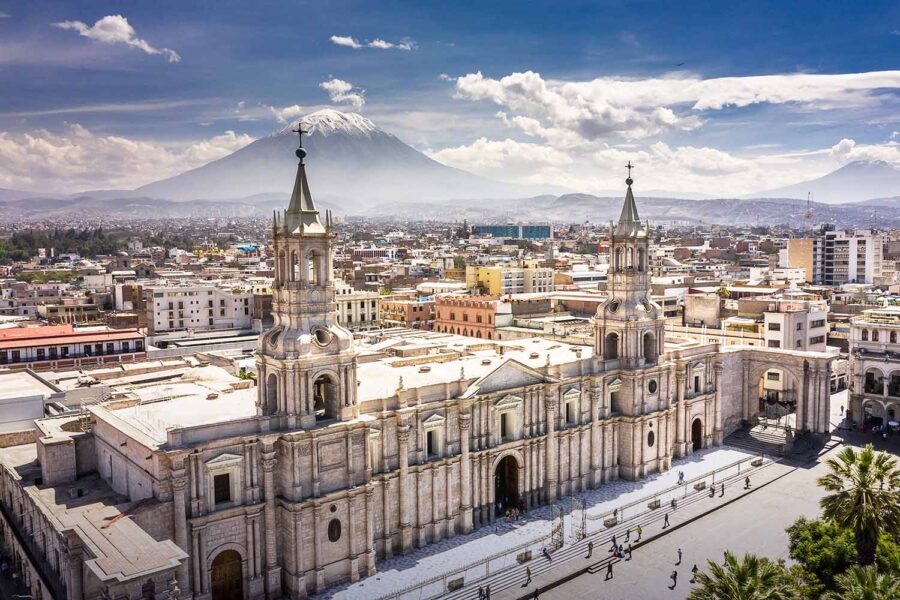 Panoramic view of Arequipa cathedral and historic city center with distant snow-capped volcano.