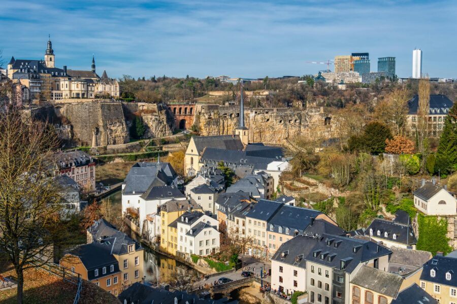 Picturesque Luxembourg City with historical architecture, cliffs, waterway, and modern skyline.