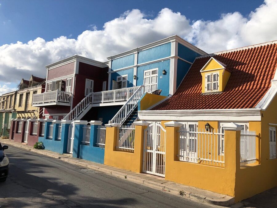 Colorful historic houses line a street in the Pietermaai District of Curacao, reflecting the area's unique charm.
