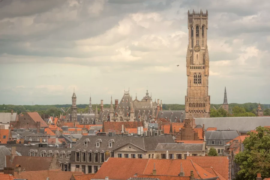 Belfry of Bruges rising above historic medieval rooftops in Belgium.