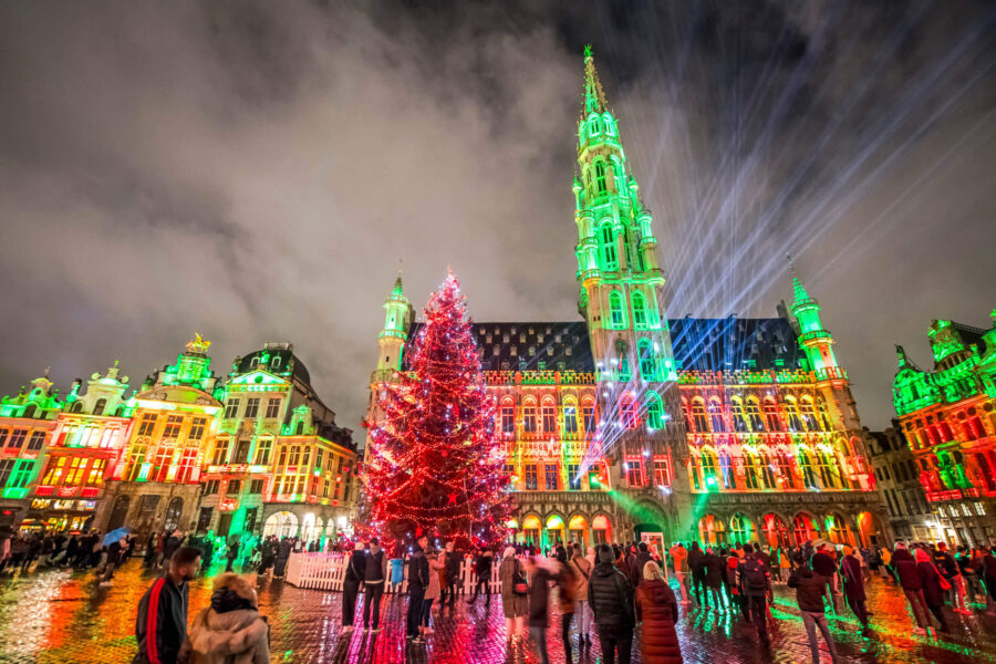 Gothic town hall square Christmas tree light show at night with projection mapping.